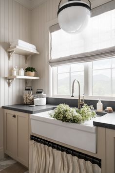 a white kitchen sink sitting under a window