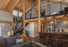 a living room filled with furniture next to a kitchen and dining area in a loft