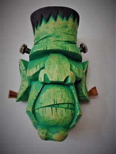 a green paper mache with a top hat on it's head and teeth