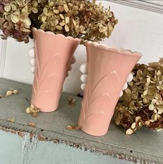 two pink vases sitting next to each other