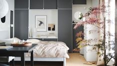 a bedroom with grey walls and white furniture