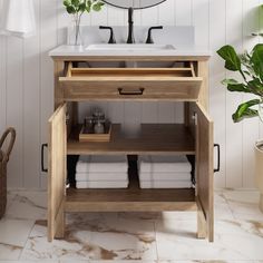 a bathroom with a sink, mirror and towel rack on the wall next to a potted plant