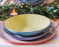 a table set for christmas with plates and candles