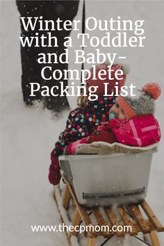 a baby sitting in a sled with the words winter outing with a toddler and baby complete packing list