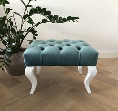 a blue bench sitting on top of a wooden floor next to a potted plant