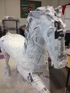 a horse made out of newspaper sitting on top of a table