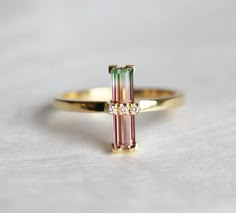 One of a kind, beautiful diamond and bi-color tourmaline ring in 18k yellow gold. The depicted ring has been sold. The tourmaline in the photos measured approx. 13 x 3.2 mm. The design can be made with gemstones of your choosing. If you would prefer a custom ring, please contact us before Watermelon Tourmaline Engagement Ring, Classy Rings, Jewellery Men, Watermelon Tourmaline Ring, Baguette Engagement Ring, Tourmaline Engagement Ring, Unique Diamond Engagement Rings, Zierlicher Ring, Unique Diamond Rings