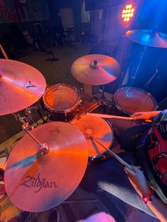 a person playing drums in a room with blue lights