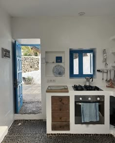 a kitchen with an oven, sink and blue doors