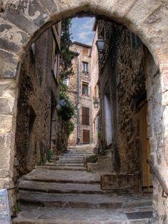 an alleyway with stone steps leading up to buildings