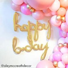 balloons and streamers with the words happy baby spelled in gold foil on a white background