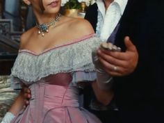 a man standing next to a woman in a pink dress