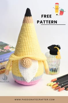 a crocheted doll with a graduation cap on it's head next to books and pencils