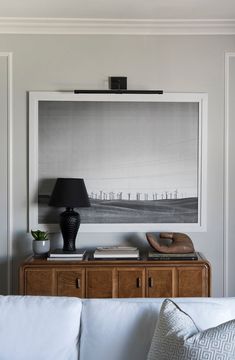 a living room scene with focus on the couch and table lamp in the foreground