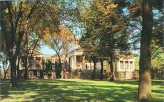 an old house surrounded by trees and grass