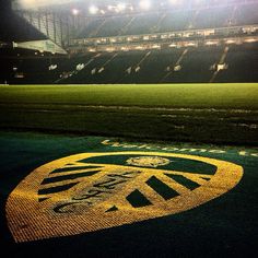 an empty soccer field at night with the lights on