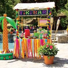 a tiki bar decorated with colorful streamers and decorations next to a swimming pool