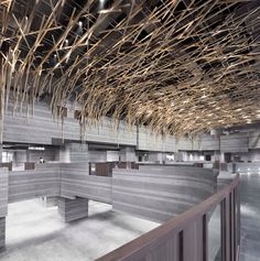 the interior of an office building with wooden beams and concrete walls that are covered in bamboo sticks