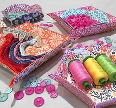 sewing supplies are displayed on a table with colorful thread and spools in them