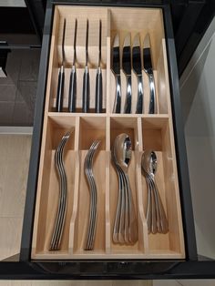 an open drawer with silverware in it