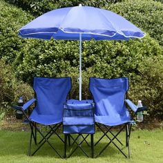 two chairs and an umbrella in the grass