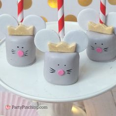 some little mouses are sitting on a plate with candles in their heads and ears