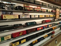 there are many toy trains on the shelves