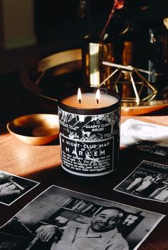 a candle sitting on top of a table next to pictures