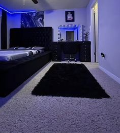 a bed room with a neatly made bed and a black rug