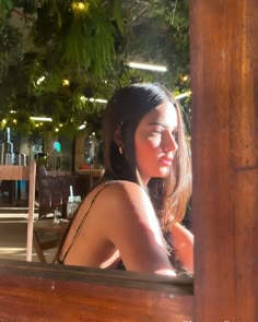 a woman sitting in a restaurant looking out the window