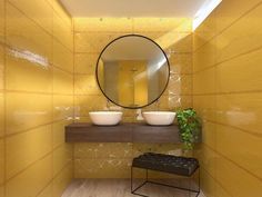 a yellow bathroom with two sinks and a round mirror on the wall, along with a stool