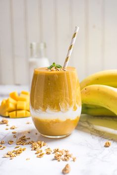 a smoothie in a glass next to some bananas