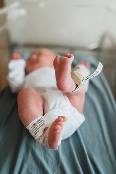 a baby laying on top of a bed wearing a diaper