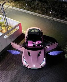 a pink sports car parked in front of a building