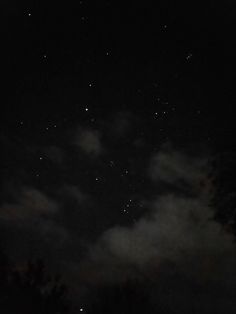 the night sky is dark and cloudy with stars in the distance, as well as some clouds