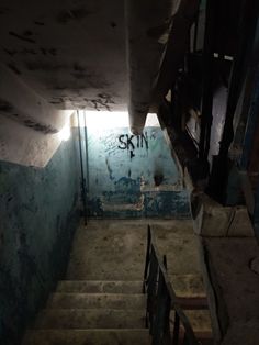 an abandoned stairway with graffiti on the walls