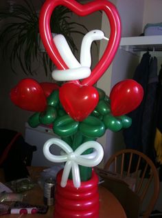 an arrangement of balloons in the shape of birds and hearts on top of a table