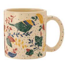 a coffee mug with colorful birds and leaves painted on the outside, sitting in front of a white background