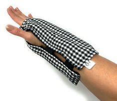 a woman's arm wrapped in a black and white checkered cloth with a tag on it