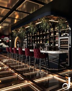 a dimly lit bar with red velvet chairs