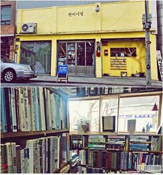 there are many books on the shelves in front of this building and one has a car parked next to it