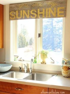 a kitchen sink under a window with the words sunshine on it and an owl statue