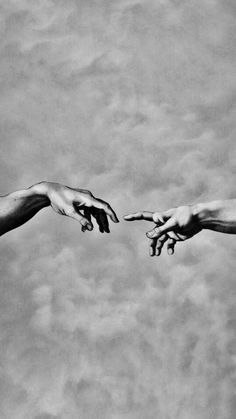 two hands reaching out towards each other in front of a cloudy sky with white clouds