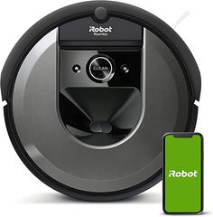 a robot that is next to a phone and a green screen on the floor with it's logo