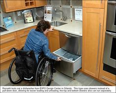 a woman in a wheel chair looking at an open dishwasher