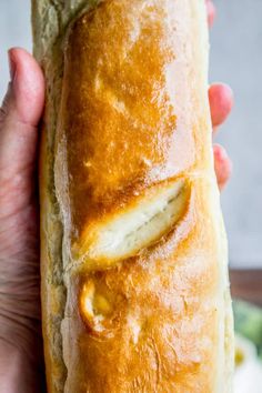 a close up of a person holding a loaf of bread