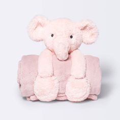 a pink teddy bear sitting on top of a pink towel with its eyes closed and ears folded