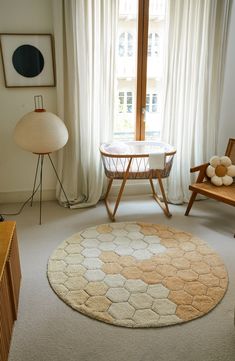 a living room with a round rug on the floor next to a chair and table