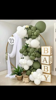 a baby shower with balloons and greenery