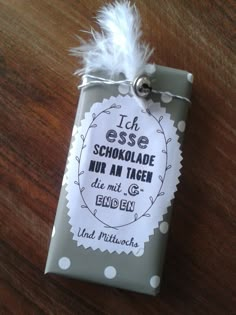 a gift wrapped in white paper with a label on it that says, i'm esse schokoladde her an tagen die mit eben